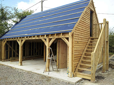 timber frame garage with steps leading to tool shed